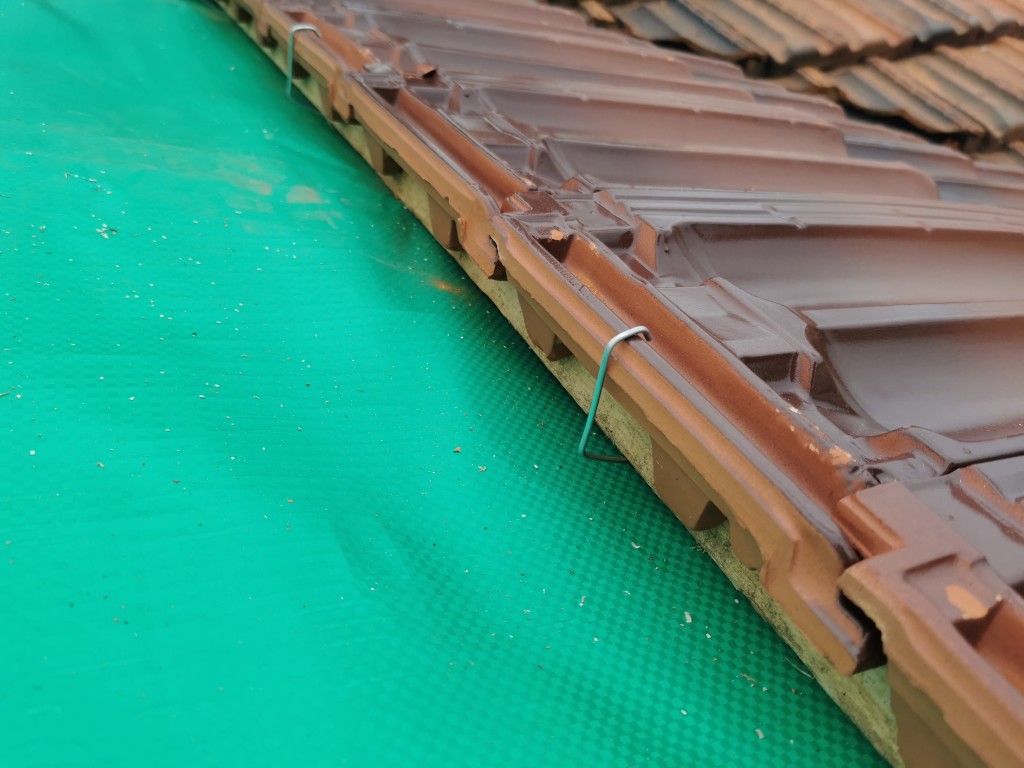 Roof tile secured to batten with clip